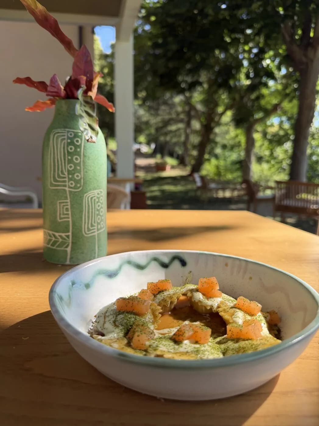Un piatto di pasta ripiena sul tavolo in terrazza, al tramonto.