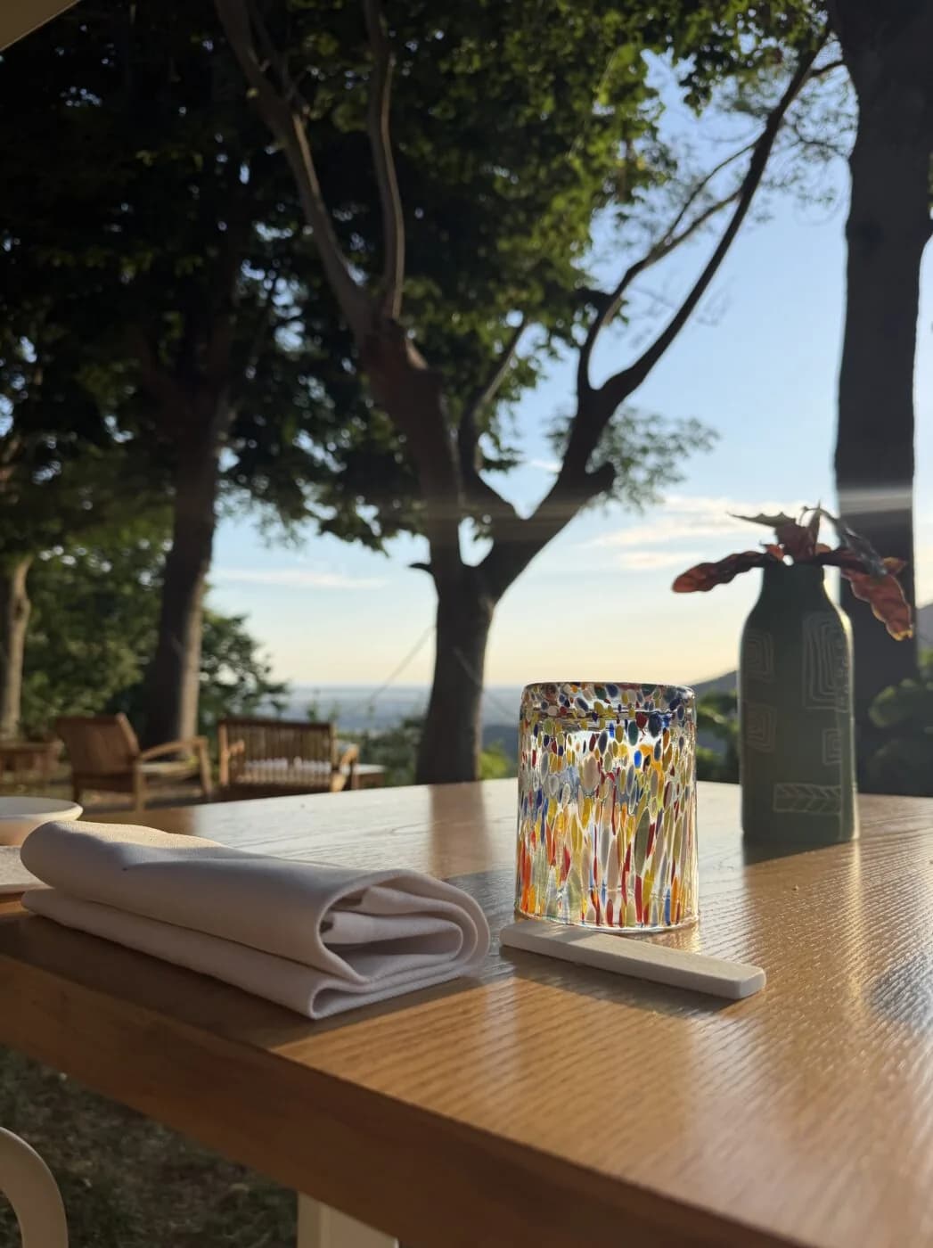 Un tavolo apparecchiato in terrazza, con la vista sulla valle.